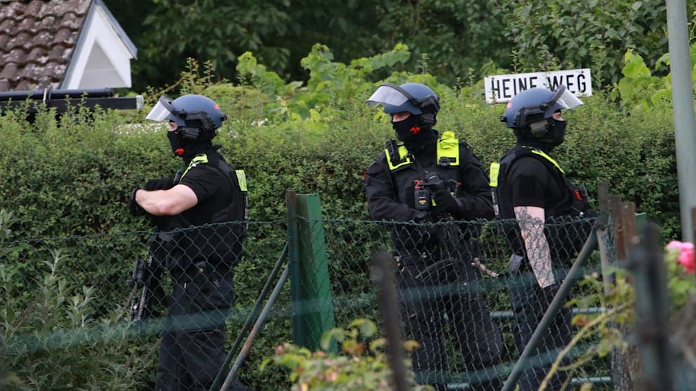 Rund um eine Gartenparzelle in Berlin-Spandau, wo sich der CSD-Attentäter Abdul Ballout (21) versteckt hielt, sichern Bereitschaftspolizisten das Gelände.